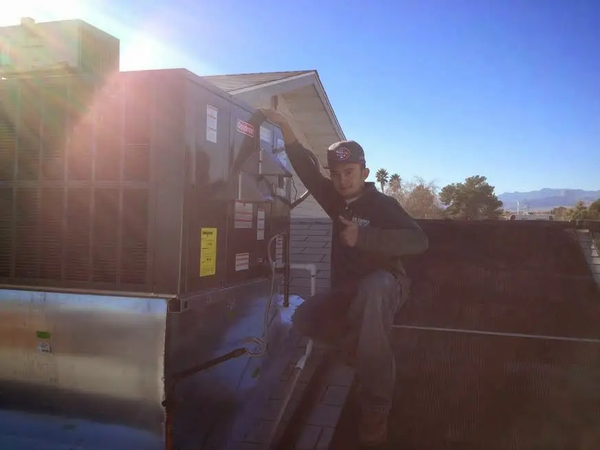 HVAC technician performing Boiler Repair on a rooftop unit in Wynne